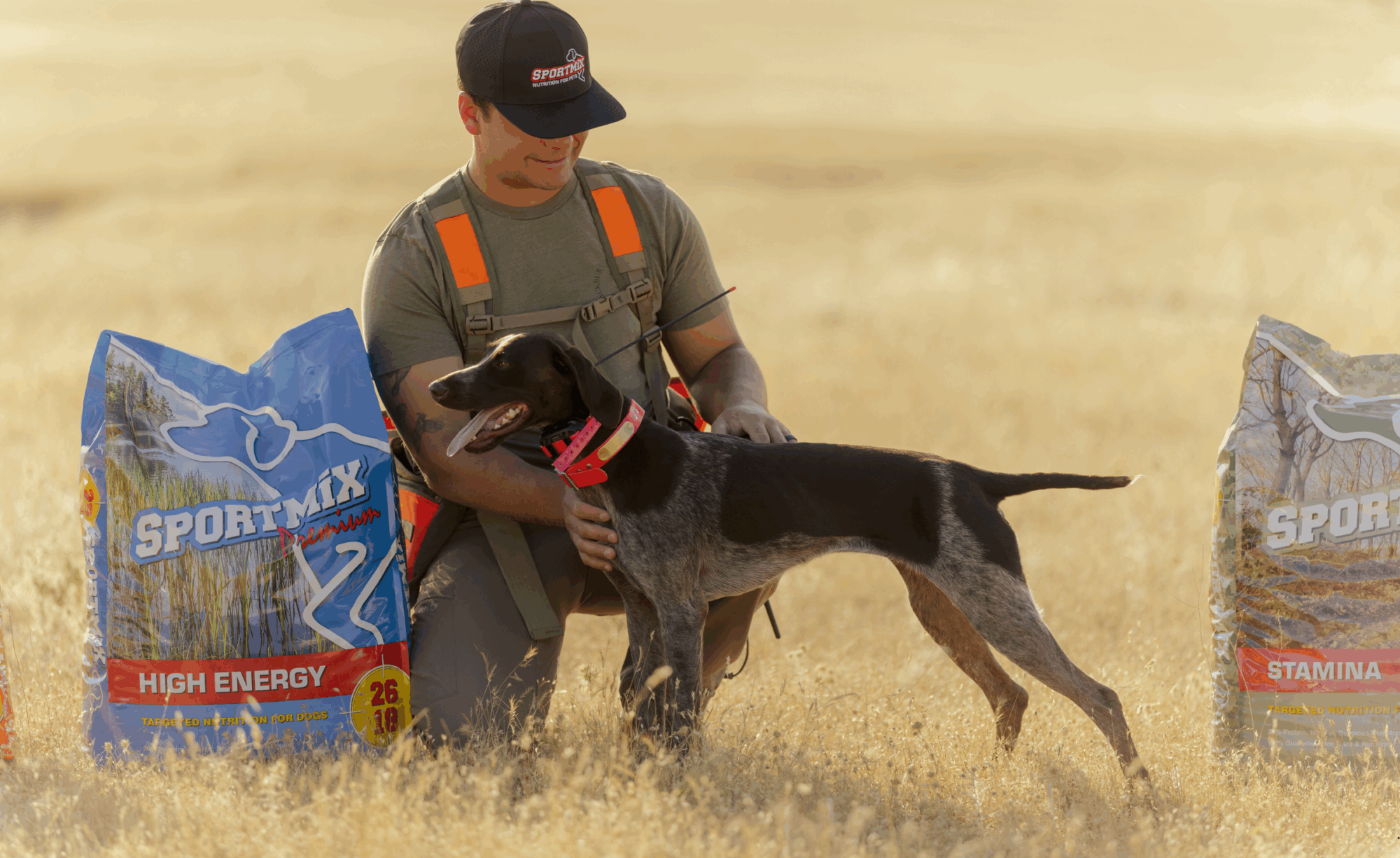 Person and dog sit in field next to a bag of dog food
